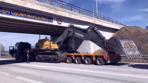 半掛車運輸挖掘機遇限高橋，老司機巧妙應對顯功力